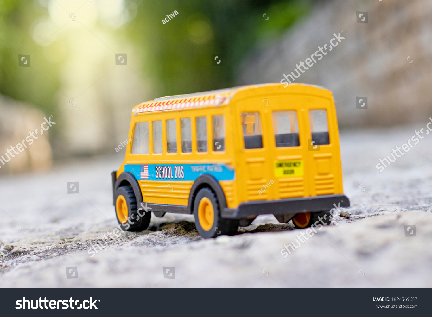 stock-photo-a-student-bus-toy-on-a-sidewalk-in-the-garden-1824569657.jpg